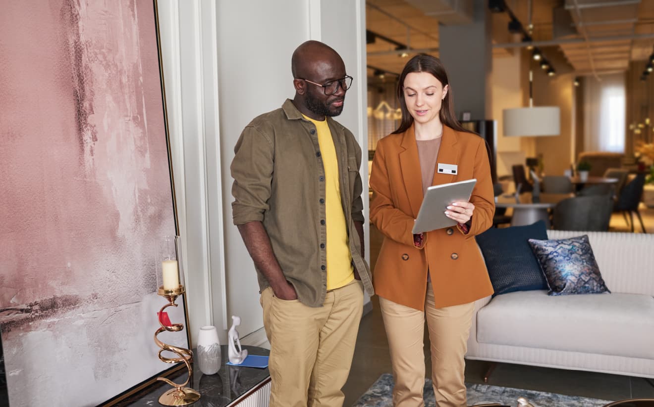 Two hotel staff members discussing and reviewing the night audit process using a tablet, ensuring the staff has the confidence to verify the audit.
