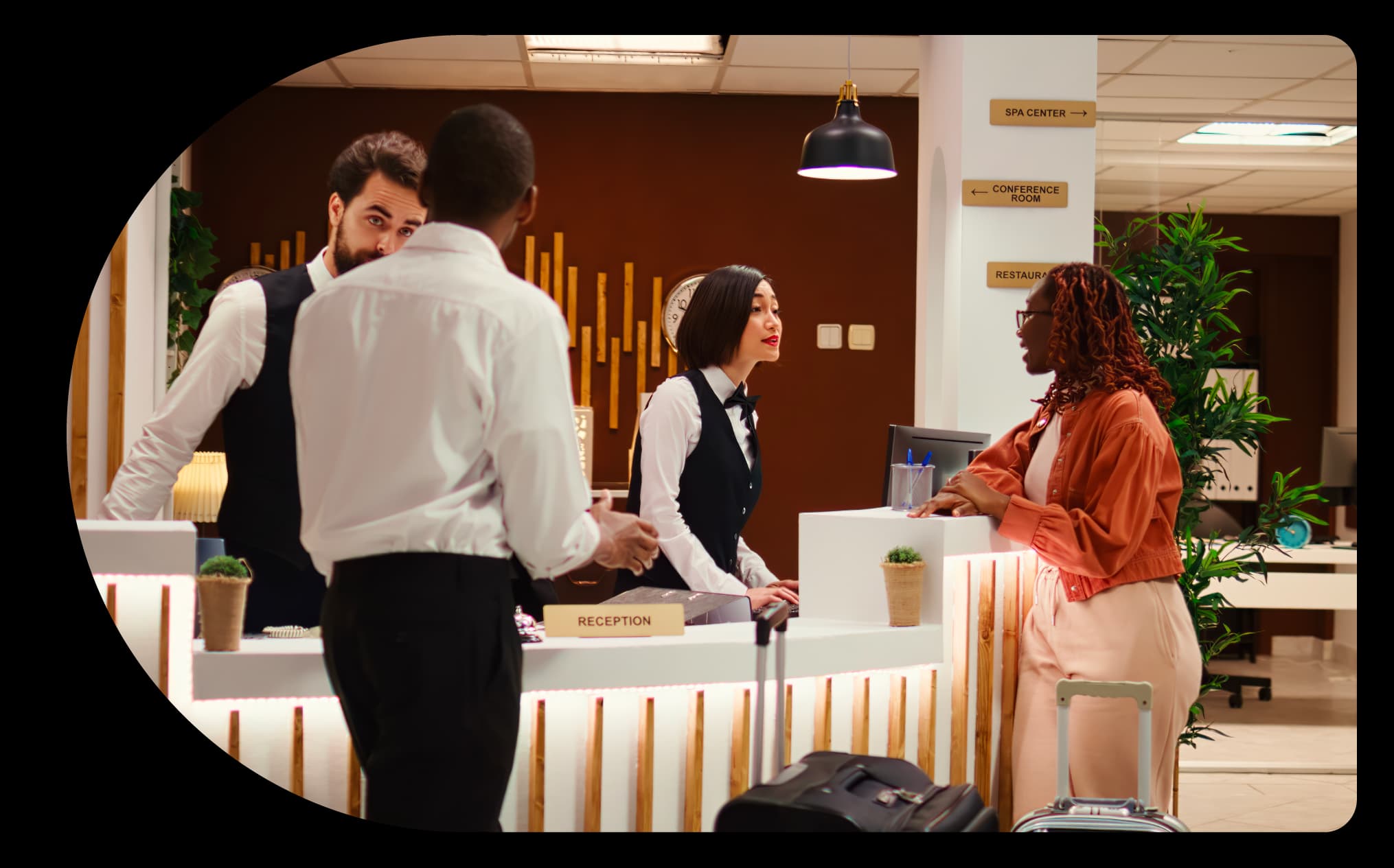 A team at the hotel reception desk, demonstrating the streamlined hotel management process with ThinkReservations, which boosts productivity and enhances the guest experience.