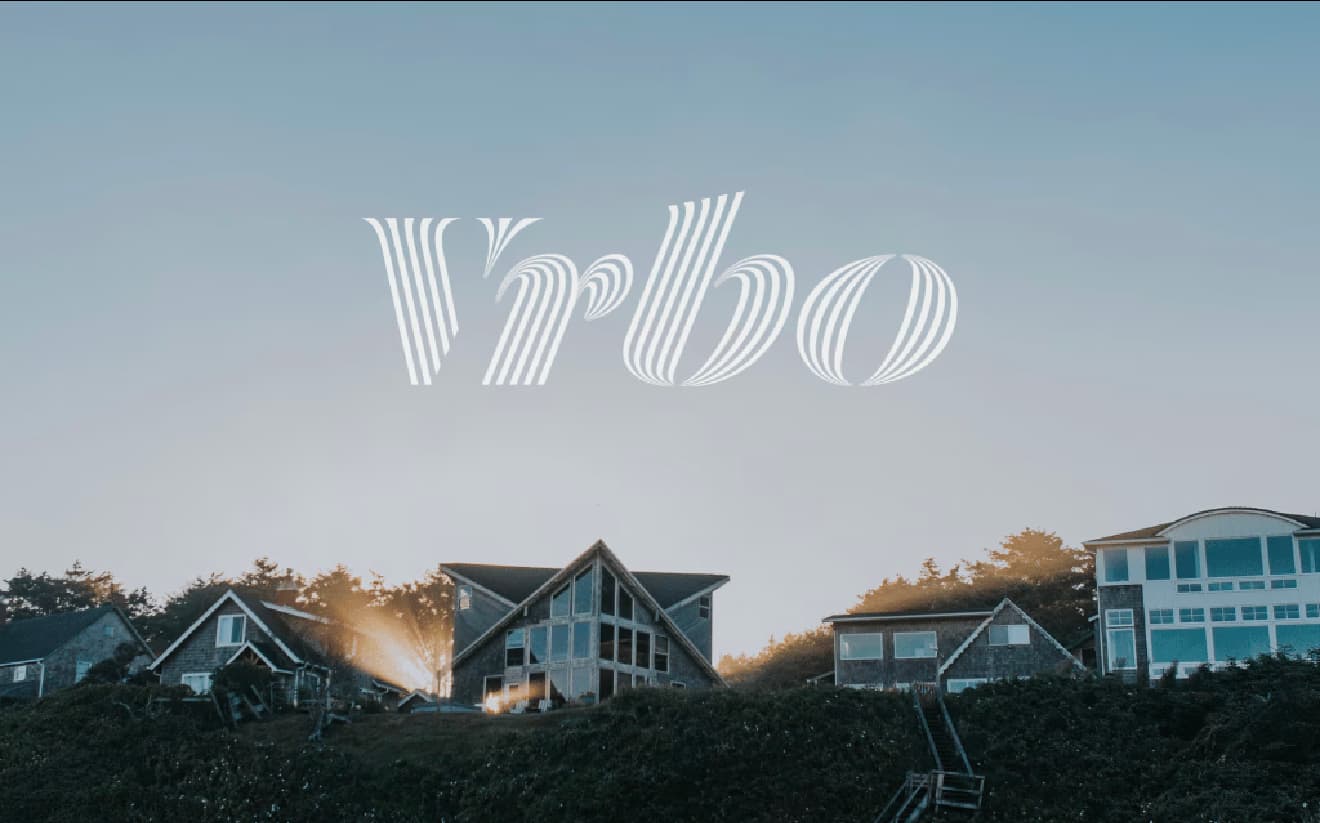 A scenic image of beachfront properties with the Vrbo logo prominently displayed in the sky.