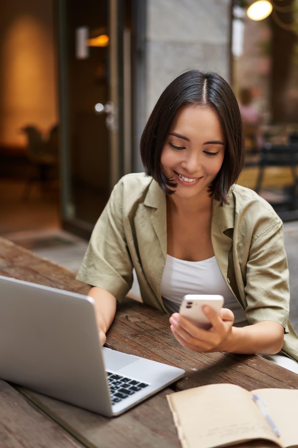 Female traveler checks both her phone and computer to book a hotel room