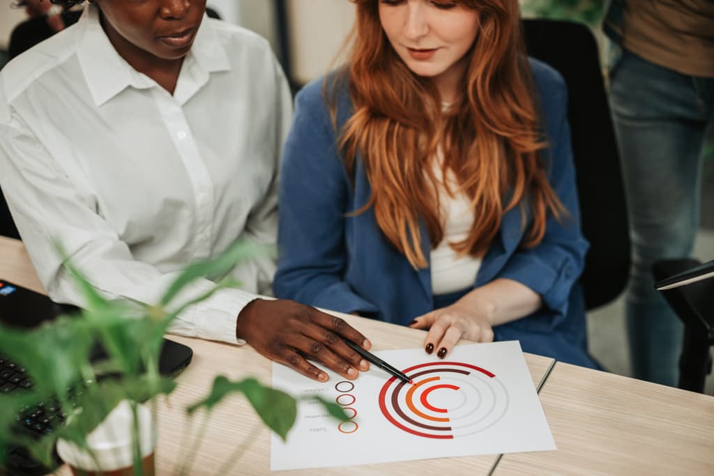 Two colleagues reviewing a report at a desk