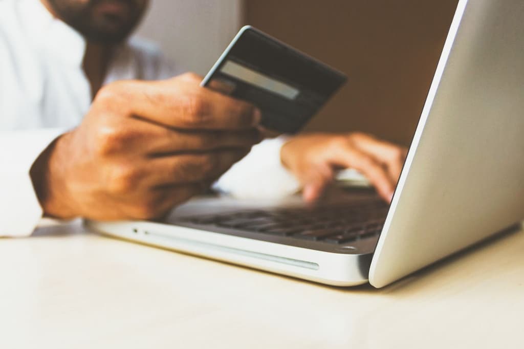 Person paying with a credit card in a laptop computer