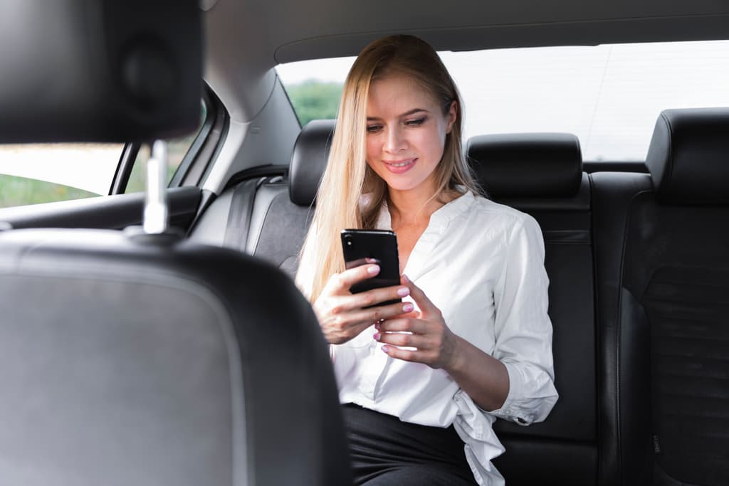A female rider checks her mobile phone on her way to the property