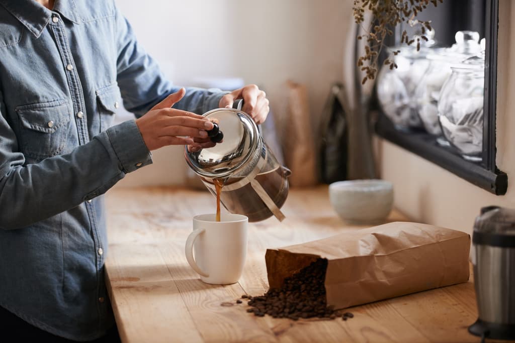 A female serves coffee in a cup