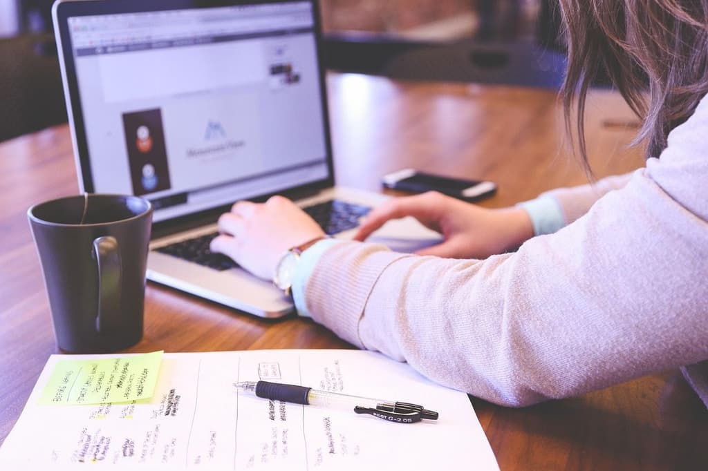 Business traveler sitting at a table with a cup of tea doing work