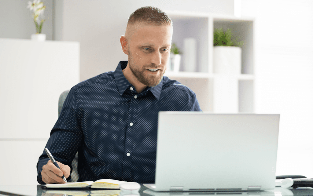 A male professional sitting in his office watching an online conference.