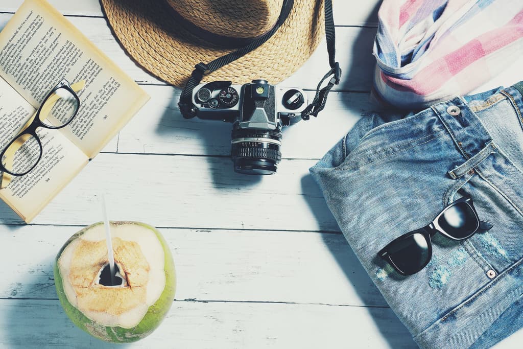 Image of things needed for a summer vacation, jeans, sunglasses, a camera, a straw hat, a good book, a coconut. Image by <a href="https://pixabay.com/users/veerasantinithi-6722948/?utm_source=link-attribution&utm_medium=referral&utm_campaign=image&utm_content=2880261">นิธิ วีระสันติ</a> from <a href="https://pixabay.com//?utm_source=link-attribution&utm_medium=referral&utm_campaign=image&utm_content=2880261">Pixabay</a>