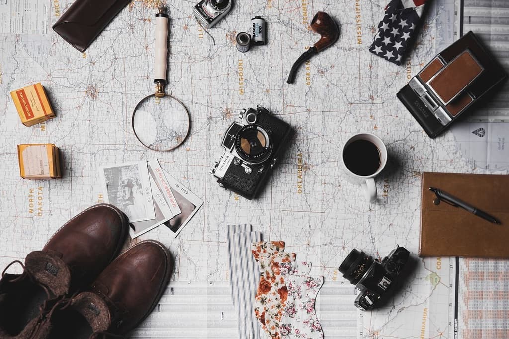 Picture of a map of north america with travel items (a couple of cameras, coffee, a notebook, a pipe, shoes, etc. Image by <a href="https://pixabay.com/users/stocksnap-894430/?utm_source=link-attribution&utm_medium=referral&utm_campaign=image&utm_content=2562138">StockSnap</a> from <a href="https://pixabay.com//?utm_source=link-attribution&utm_medium=referral&utm_campaign=image&utm_content=2562138">Pixabay</a>